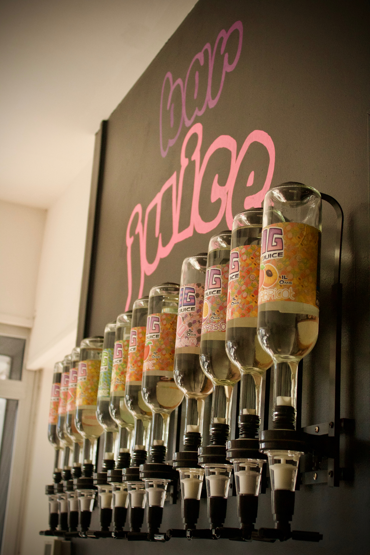 Le mur Bar Juice de la boutique Chantonnay : rangée de bouteilles d'un litre retournées sous l'enseigne peinte à la main.